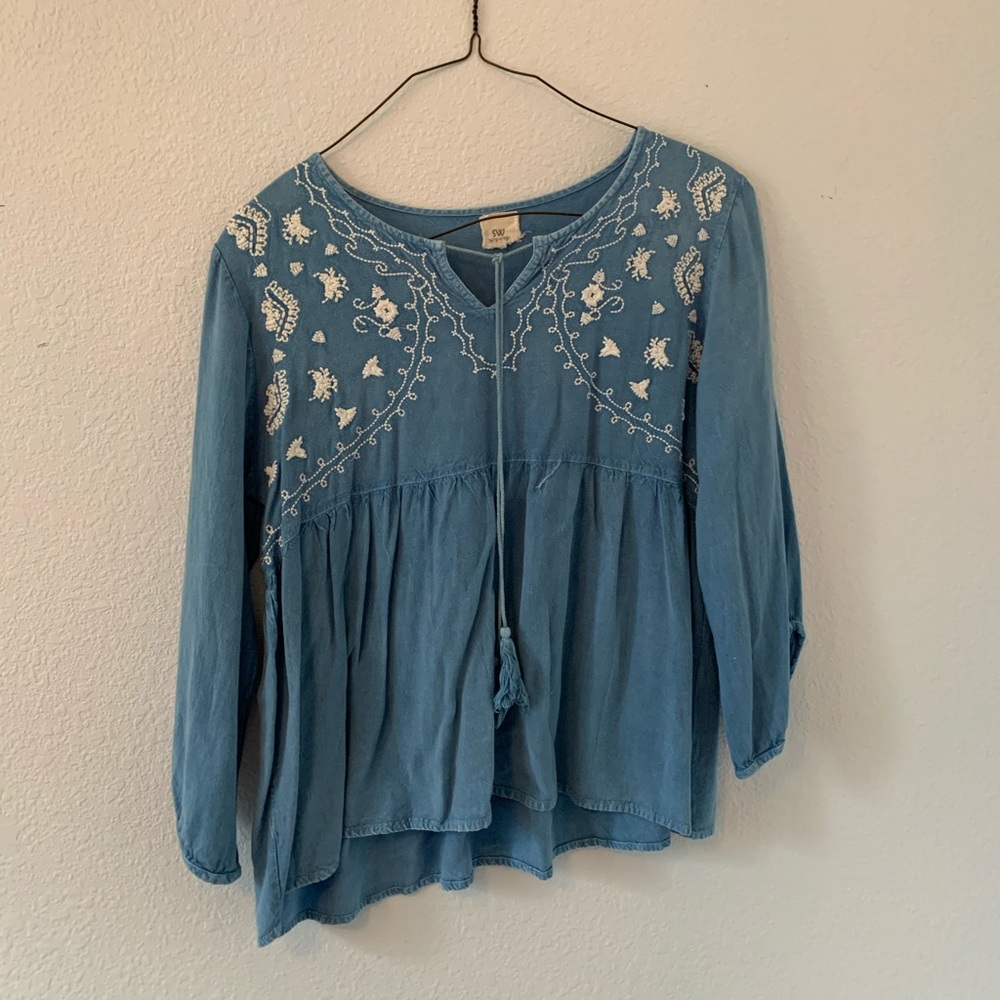 Blue blouse with embroidered detailing.
